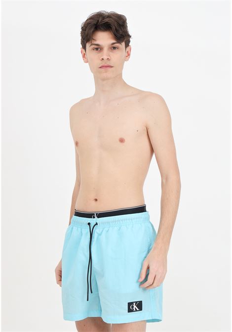 Turquoise men's swim shorts with logo patch and elasticated slip model CALVIN KLEIN | KM0KM00981CSY